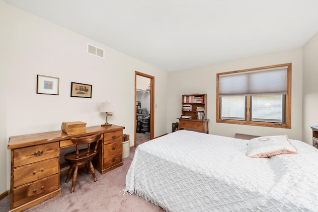 bedroom with light colored carpet, a spacious closet, and a closet