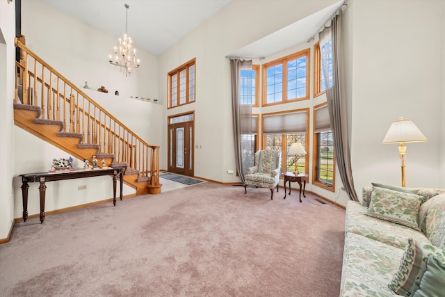 carpeted foyer featuring a chandelier and a towering ceiling