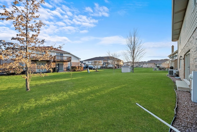 view of yard with central AC and a storage shed