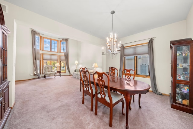 carpeted dining area with a chandelier