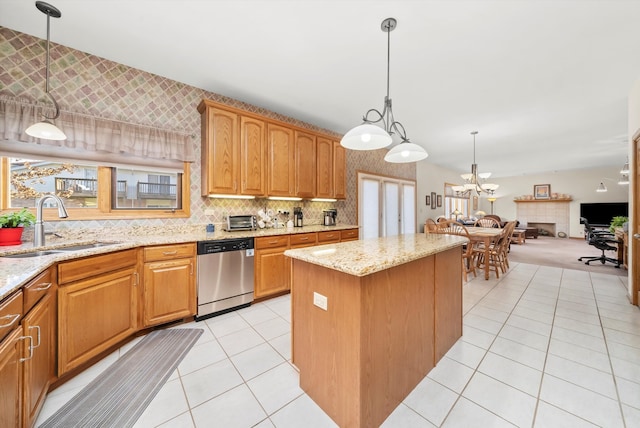 kitchen featuring light stone countertops, hanging light fixtures, a center island, and stainless steel dishwasher