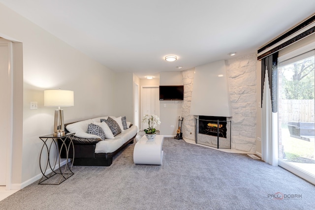 carpeted living room featuring a fireplace