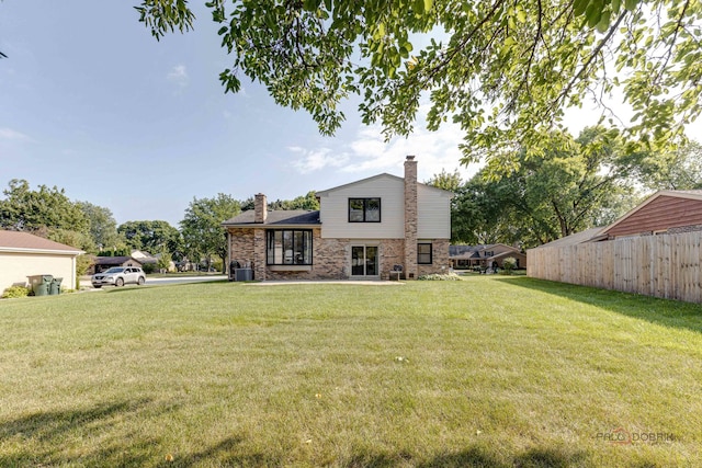 rear view of house featuring a yard