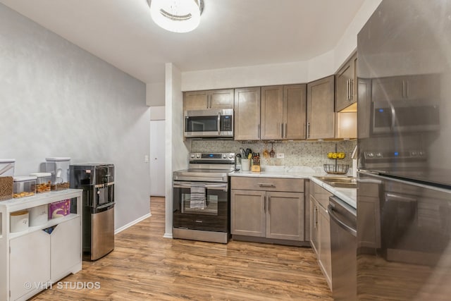 kitchen featuring decorative backsplash, stainless steel appliances, and wood-type flooring