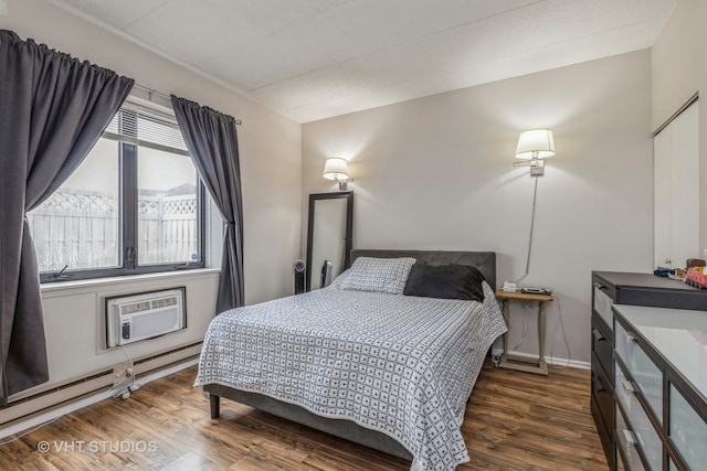 bedroom featuring a wall mounted AC and dark wood-type flooring