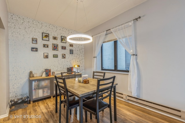 dining area with hardwood / wood-style floors and a baseboard radiator