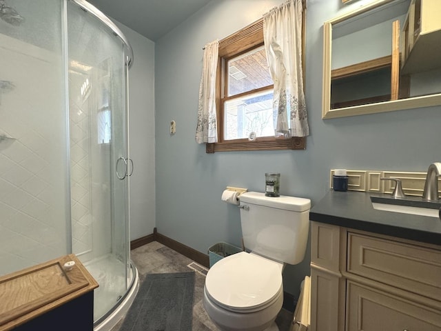 bathroom featuring vanity, toilet, and a shower with shower door