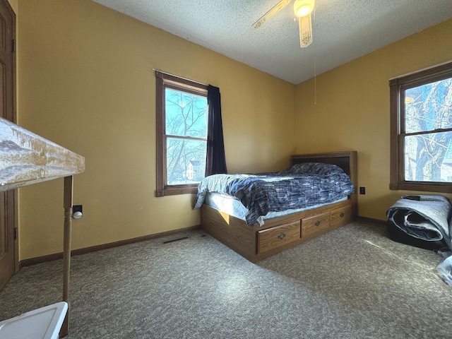 carpeted bedroom with a textured ceiling and ceiling fan