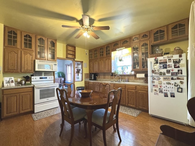 kitchen featuring hardwood / wood-style flooring, white appliances, sink, and tasteful backsplash