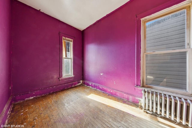 spare room featuring hardwood / wood-style flooring and radiator