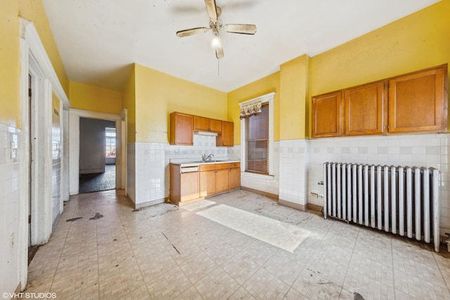 kitchen featuring brown cabinetry, light floors, tile walls, and radiator heating unit