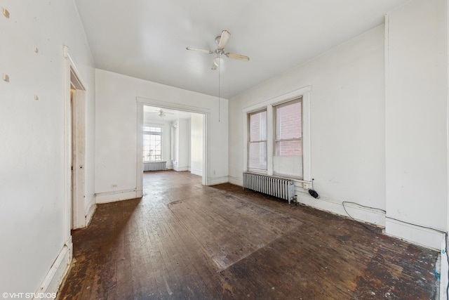 unfurnished room with radiator, baseboards, a ceiling fan, and hardwood / wood-style flooring