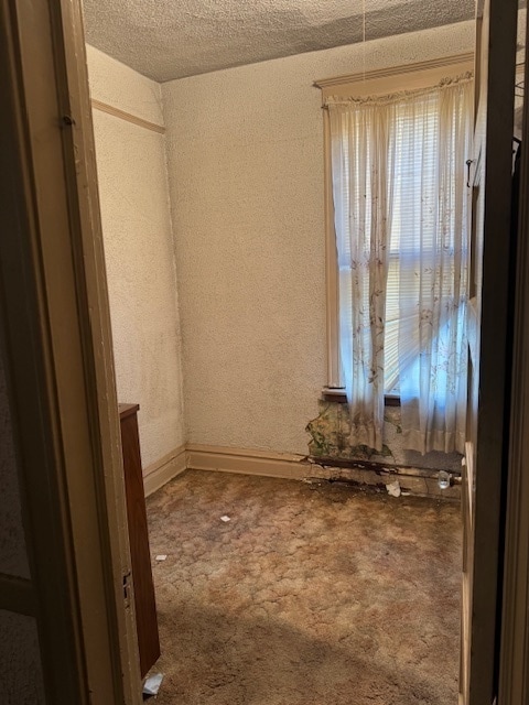 empty room with a textured ceiling and carpet floors