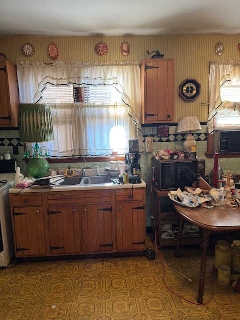 kitchen featuring decorative backsplash, sink, and stainless steel stove