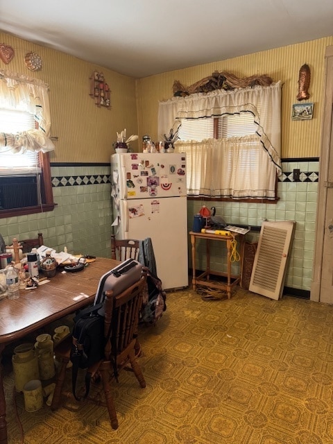 dining area featuring tile walls