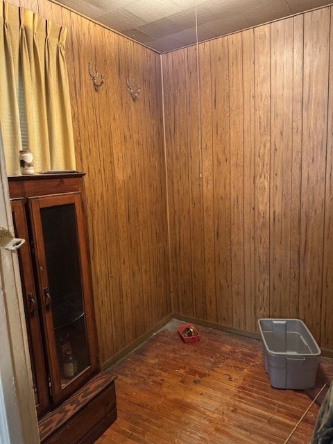 unfurnished room featuring dark hardwood / wood-style floors and wooden walls