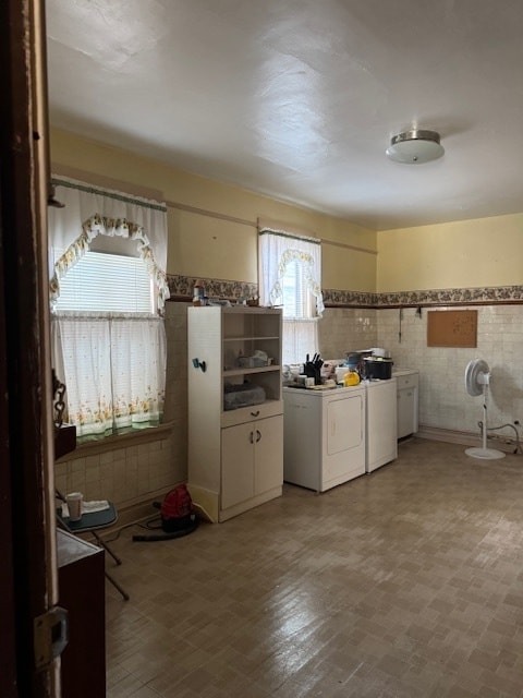 kitchen featuring white cabinetry, tile walls, and a healthy amount of sunlight