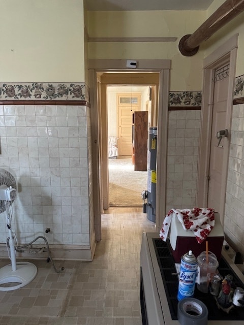 bathroom featuring water heater and tile walls