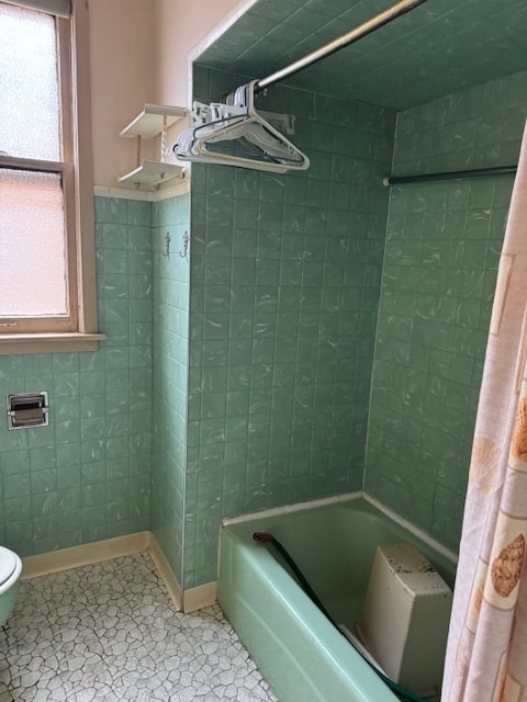 bathroom featuring tile patterned floors, shower / bath combo with shower curtain, and toilet