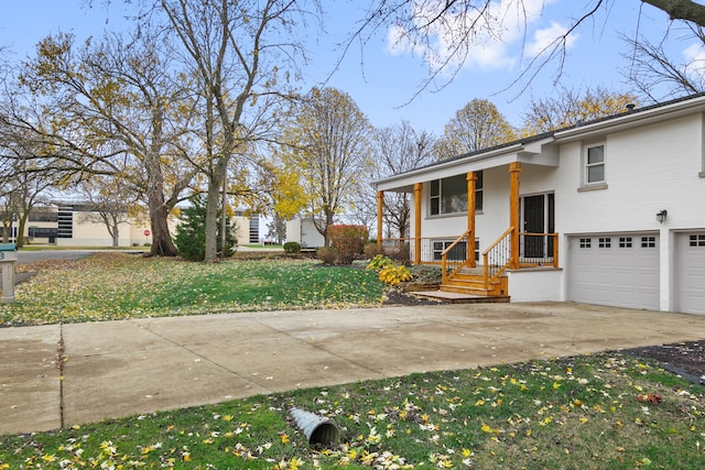 view of side of home with a porch, a garage, and a lawn