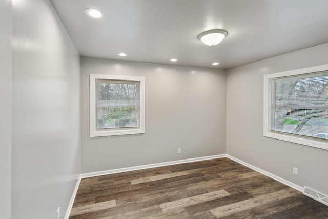 unfurnished room with dark hardwood / wood-style flooring and a wealth of natural light