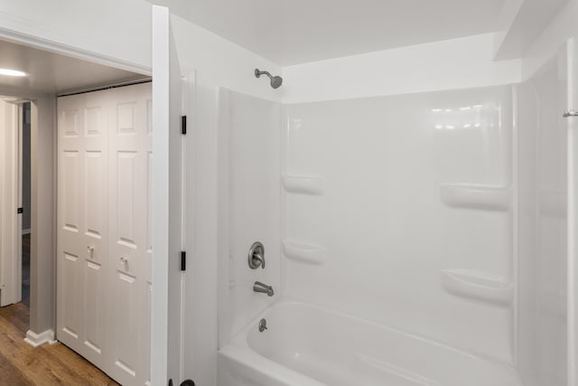 bathroom featuring washtub / shower combination and wood-type flooring