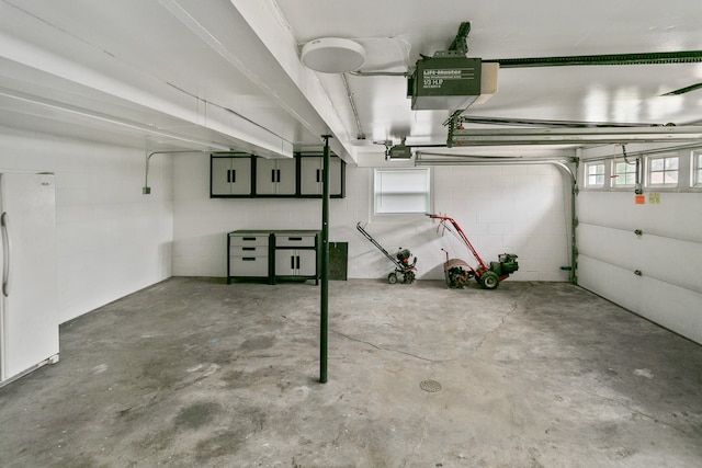 garage featuring white refrigerator and a garage door opener