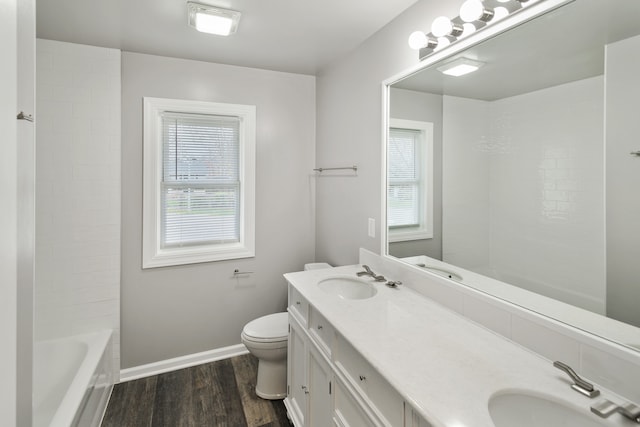 bathroom with a wealth of natural light, vanity, wood-type flooring, and toilet