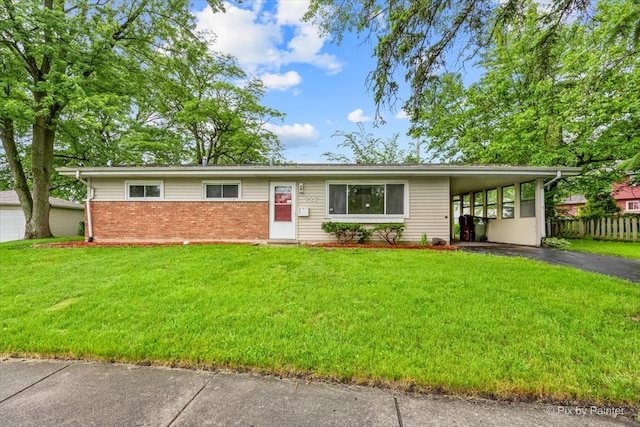 ranch-style home featuring a carport and a front lawn