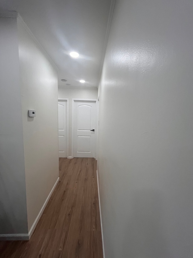 hallway featuring hardwood / wood-style floors and ornamental molding