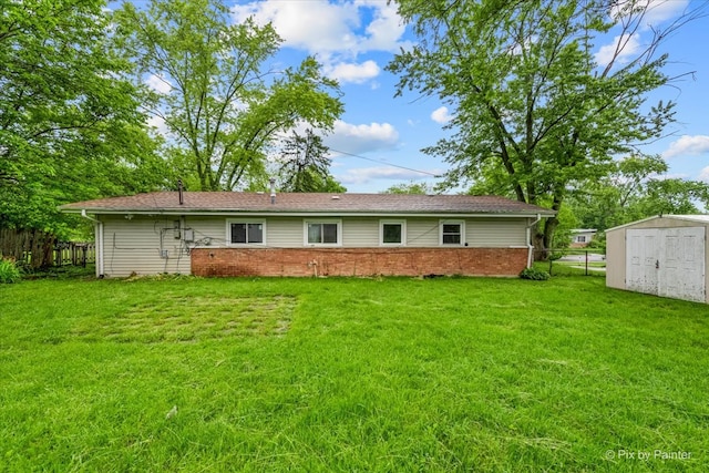 rear view of house featuring a storage shed and a lawn