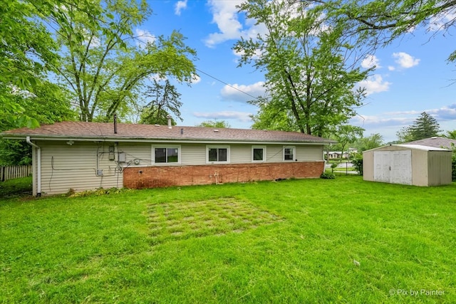 rear view of house featuring a storage unit and a yard