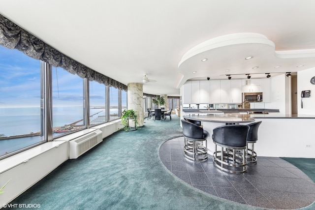 carpeted dining room with a wall mounted air conditioner and a water view