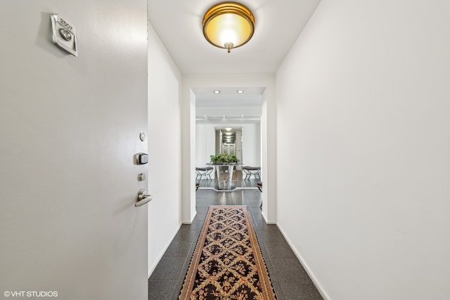 hall with dark tile patterned flooring