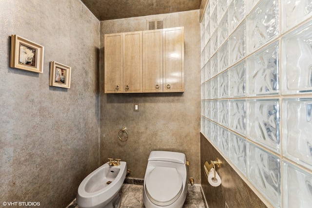 bathroom featuring toilet and a bidet