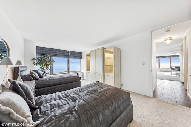 bedroom with carpet flooring and a water view