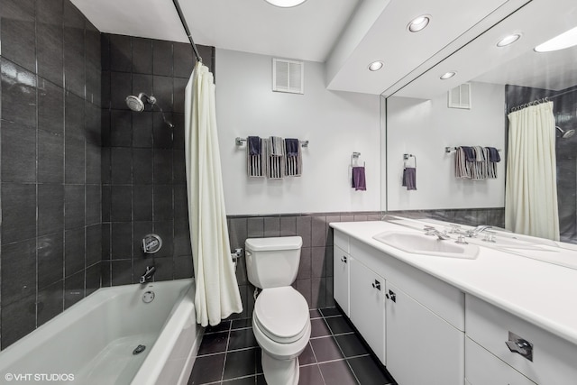 full bathroom featuring vanity, tile patterned flooring, toilet, shower / bathtub combination with curtain, and tile walls