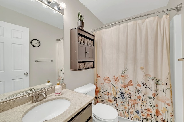 bathroom with walk in shower, vanity, and toilet