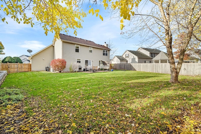 rear view of property featuring a lawn