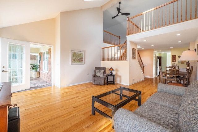 living room featuring ceiling fan, hardwood / wood-style floors, and high vaulted ceiling