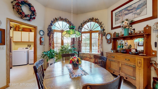 dining area with a notable chandelier and washer and dryer