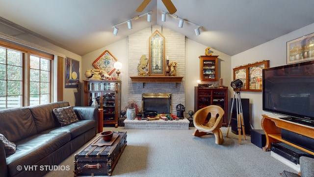 living room with lofted ceiling, rail lighting, carpet flooring, ceiling fan, and a fireplace