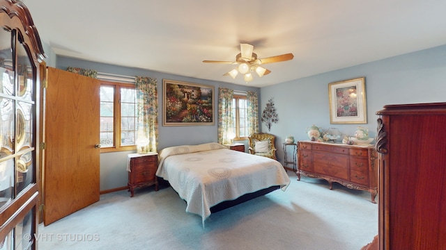 bedroom with light carpet, multiple windows, and ceiling fan