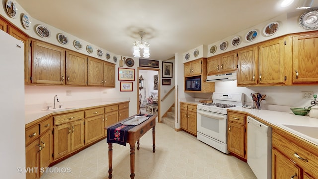 kitchen with white appliances, sink, and a chandelier