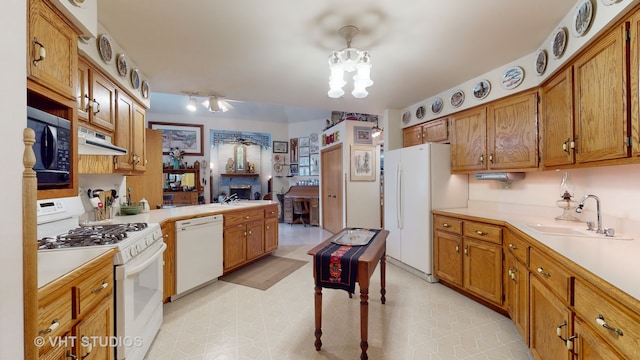 kitchen with exhaust hood, white appliances, and sink