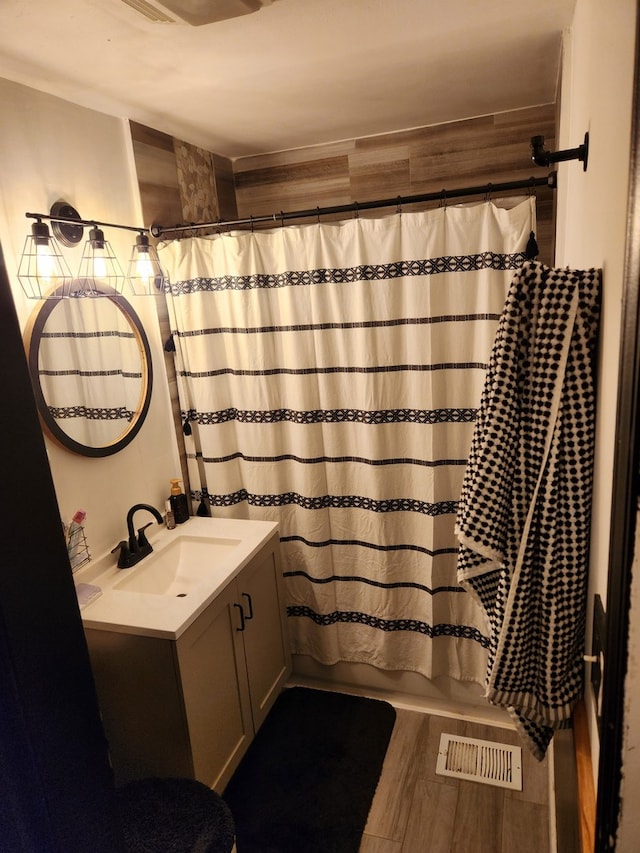 bathroom featuring shower / tub combo, vanity, and hardwood / wood-style flooring