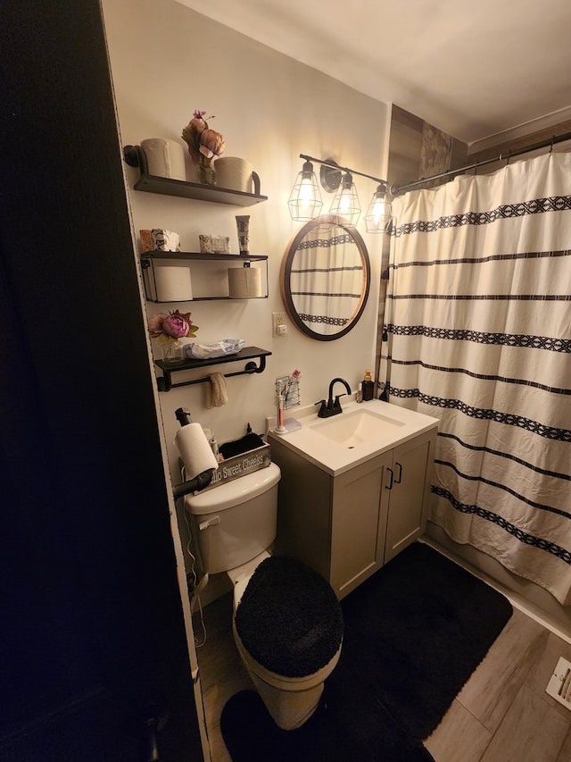 bathroom featuring curtained shower, hardwood / wood-style floors, vanity, and toilet