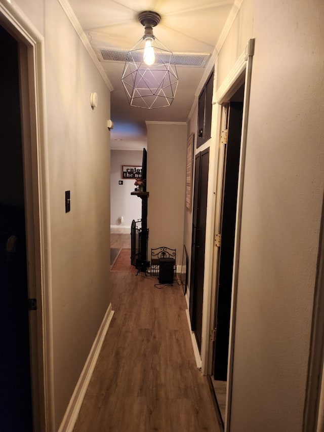 corridor featuring ornamental molding and dark wood-type flooring