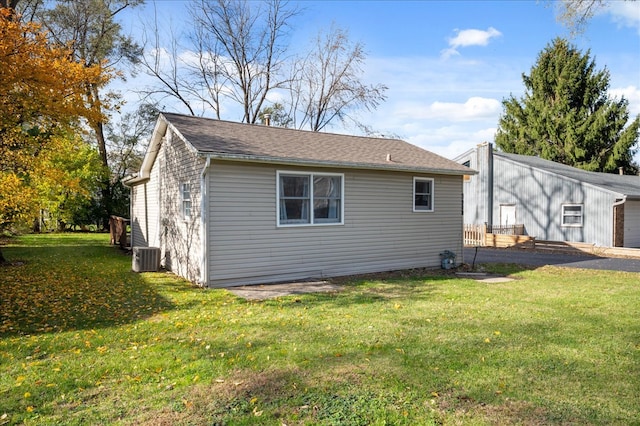 view of side of property with a yard and central air condition unit