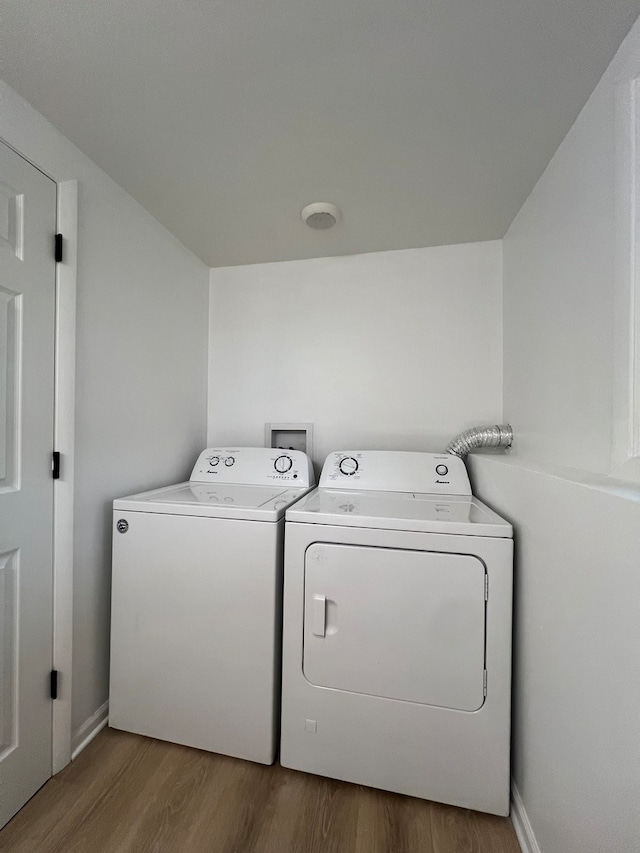 washroom with hardwood / wood-style floors and washing machine and clothes dryer